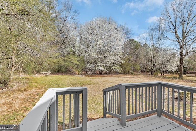 wooden terrace featuring a yard