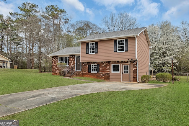 view of front facade featuring concrete driveway, a front lawn, a shingled roof, and brick siding