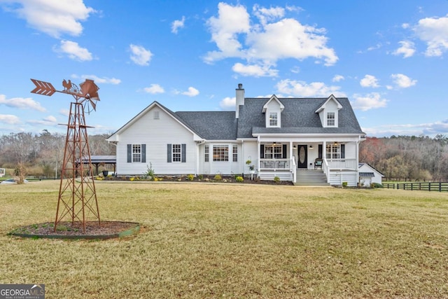 view of front of property featuring a shingled roof, a chimney, covered porch, fence, and a front yard