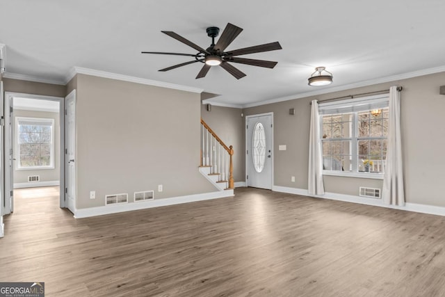 entryway featuring baseboards, visible vents, stairway, and wood finished floors