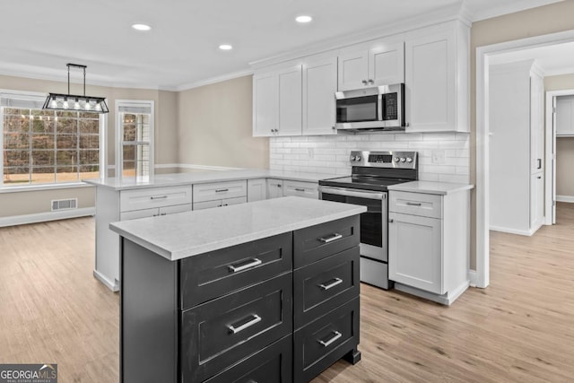 kitchen featuring stainless steel appliances, visible vents, and white cabinets