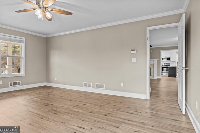 empty room featuring light wood finished floors, visible vents, and crown molding