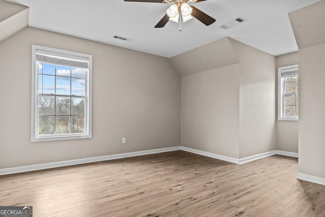 bonus room with lofted ceiling, baseboards, visible vents, and wood finished floors