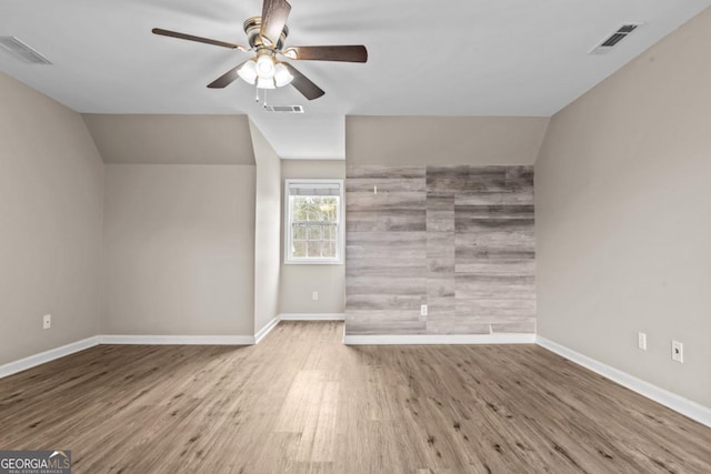 unfurnished living room featuring baseboards, visible vents, and wood finished floors