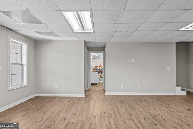 basement with a drop ceiling and wood finished floors