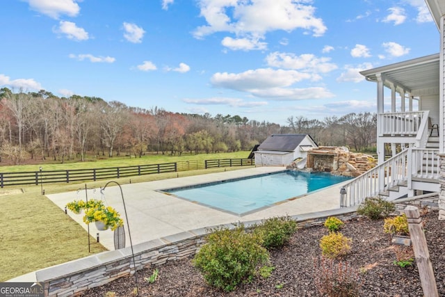 pool featuring an outbuilding, a fenced backyard, a yard, stairway, and a patio area