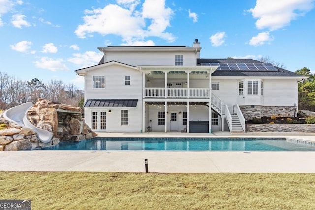 rear view of house featuring a patio, a yard, french doors, stairway, and a chimney