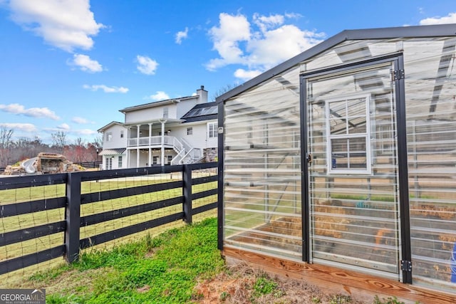 view of property exterior featuring an exterior structure, fence, an outdoor structure, and stairs