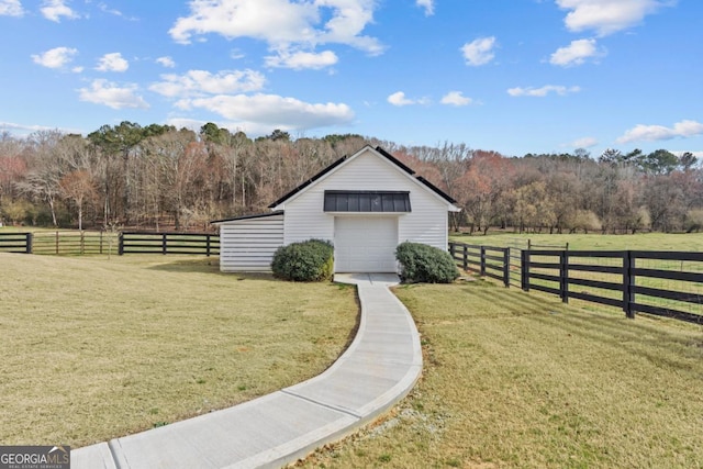 view of outbuilding featuring a rural view, an outdoor structure, a view of trees, and fence