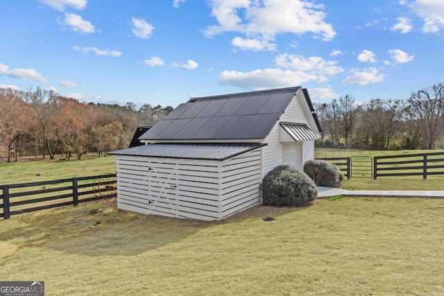 view of outbuilding featuring a rural view, an outdoor structure, and fence