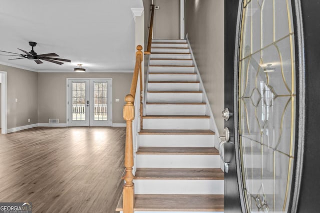 stairway featuring french doors, visible vents, crown molding, and wood finished floors