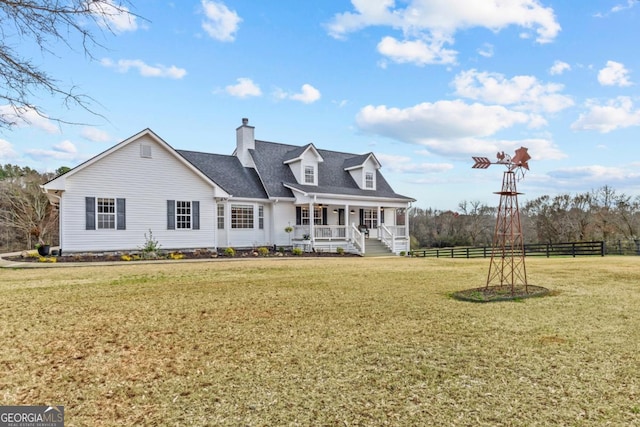 view of front of house featuring a porch, a front yard, fence, and a chimney