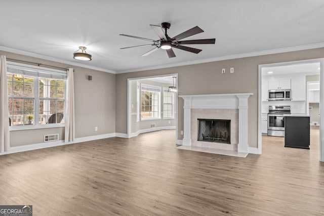 unfurnished living room featuring a fireplace with flush hearth, light wood-style flooring, and crown molding