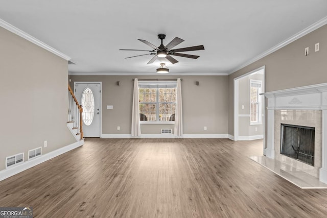 unfurnished living room featuring wood finished floors, a fireplace, baseboards, and stairs