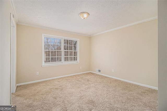 carpeted spare room featuring ornamental molding, visible vents, a textured ceiling, and baseboards