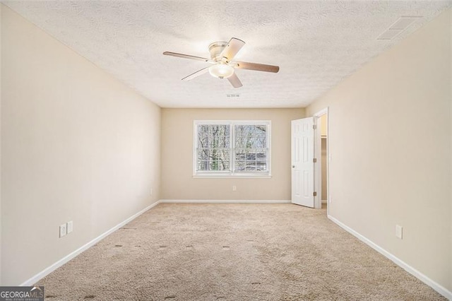 unfurnished room with a ceiling fan, carpet, a textured ceiling, and baseboards