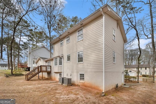 back of property with central air condition unit, stairway, and a deck