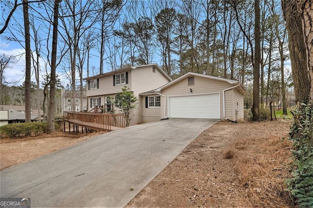 view of front of home with concrete driveway, a wooden deck, and an attached garage