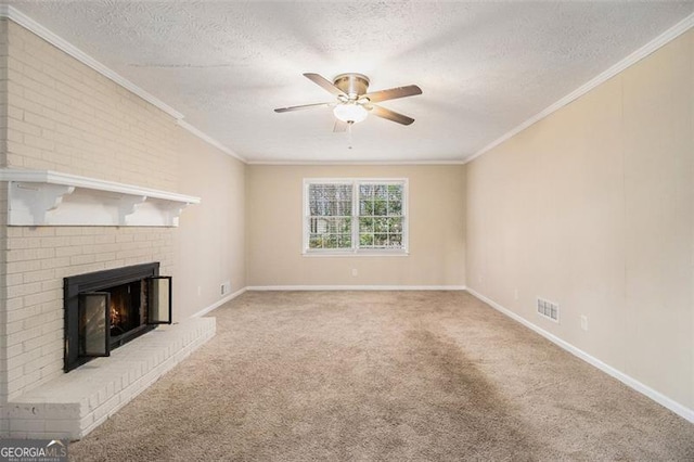 unfurnished living room with ceiling fan, carpet, a textured ceiling, crown molding, and a brick fireplace