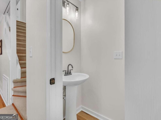 bathroom with a sink, baseboards, and wood finished floors