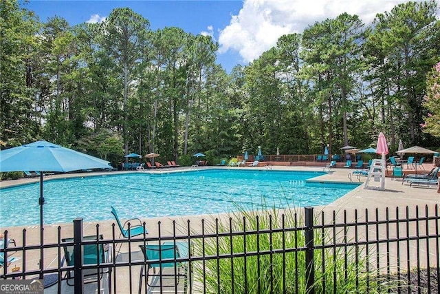 community pool with fence and a patio