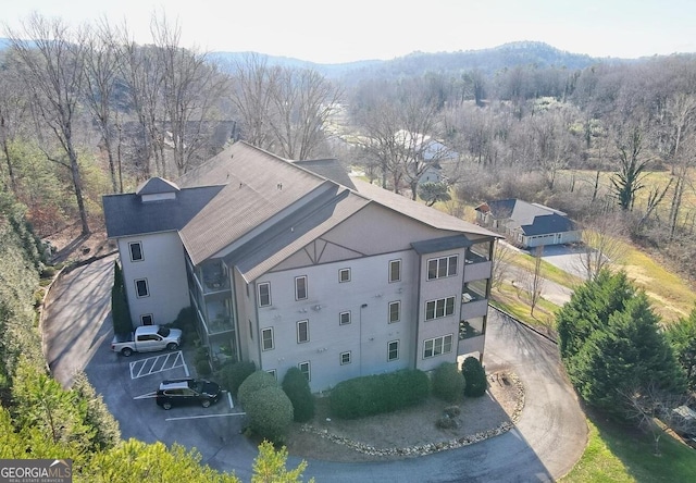 birds eye view of property featuring a mountain view and a view of trees