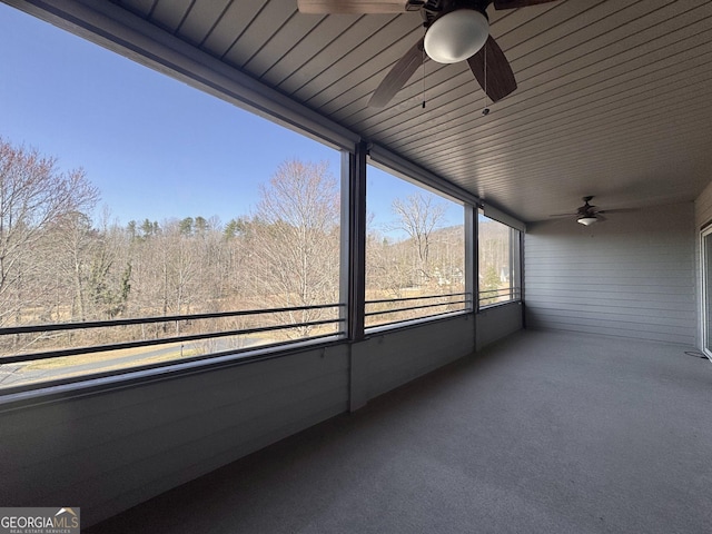 unfurnished sunroom featuring a ceiling fan