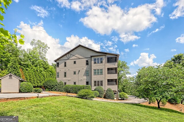116 Smoky Mountain Ln Unit 103, Clayton, GA 30525 - back of house with a lawn and a storage shed