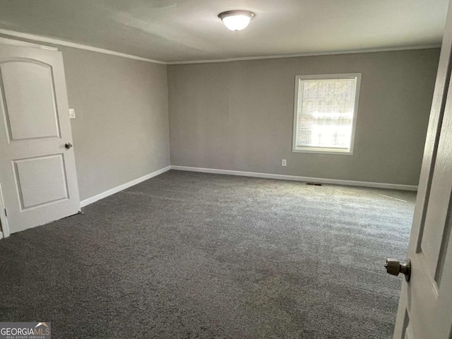 spare room with carpet, ornamental molding, and baseboards