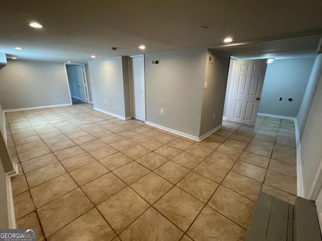 finished below grade area with recessed lighting, visible vents, baseboards, and light tile patterned flooring