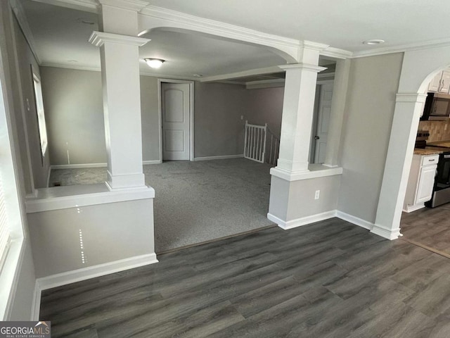 unfurnished living room with dark wood-style floors, arched walkways, crown molding, decorative columns, and baseboards