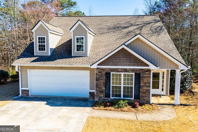 view of front of home featuring a garage, driveway, roof with shingles, and stone siding