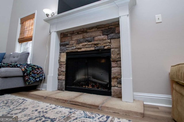 interior details featuring a fireplace, baseboards, and wood finished floors