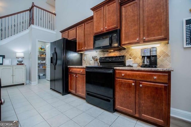 kitchen with baseboards, light tile patterned flooring, backsplash, and black appliances