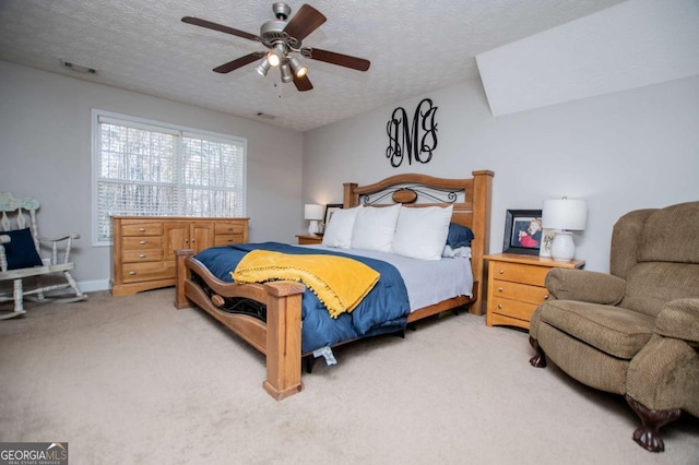 bedroom featuring light colored carpet, visible vents, ceiling fan, and a textured ceiling