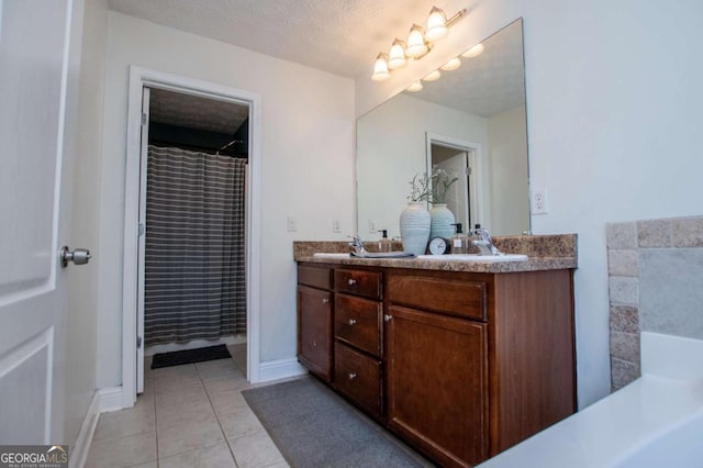 bathroom with double vanity, baseboards, tile patterned flooring, a textured ceiling, and a sink