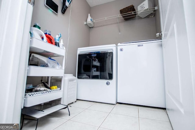 laundry room with laundry area, tile patterned flooring, and washing machine and clothes dryer