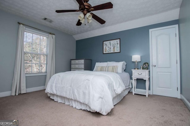 bedroom with carpet, visible vents, vaulted ceiling, and a textured ceiling