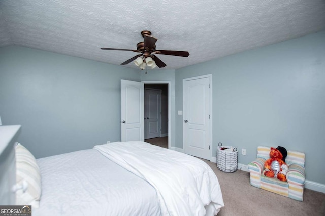 carpeted bedroom featuring ceiling fan, a textured ceiling, and baseboards