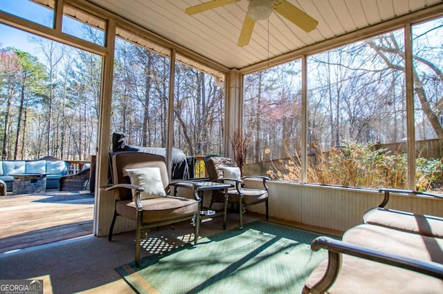 sunroom / solarium featuring a ceiling fan