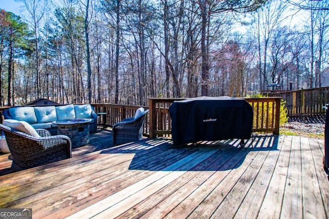 wooden terrace with a fire pit and grilling area