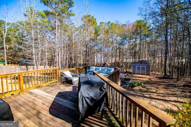 wooden terrace featuring an outbuilding, a storage unit, and a wooded view