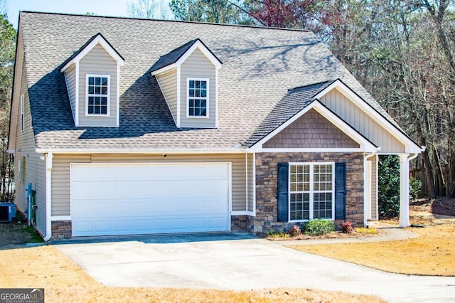 view of front of house with a garage, driveway, a shingled roof, central AC unit, and stone siding