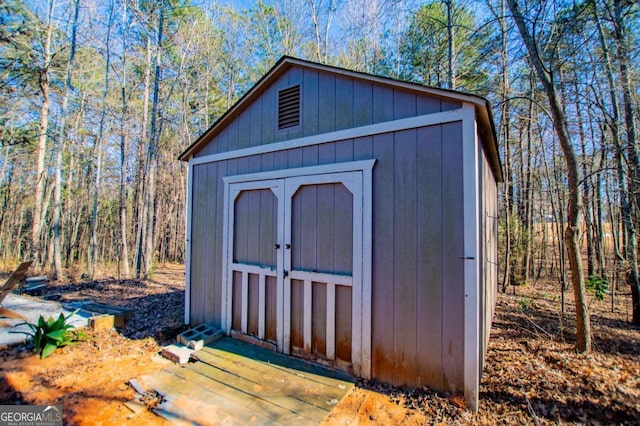 view of shed with a wooded view