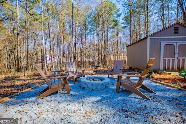 view of patio featuring a storage shed, an outbuilding, and a fire pit