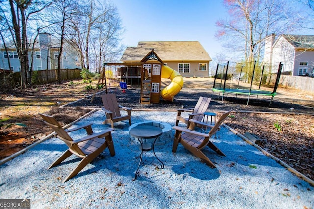 view of patio with a trampoline, fence, and a playground