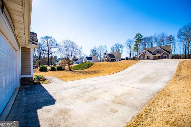 view of yard with a garage and concrete driveway