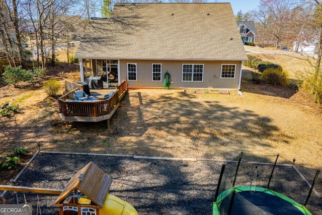 back of property featuring roof with shingles and a deck