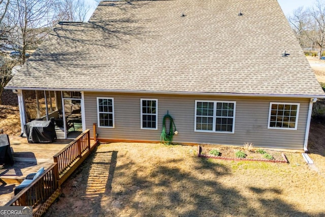 rear view of house with a deck and roof with shingles