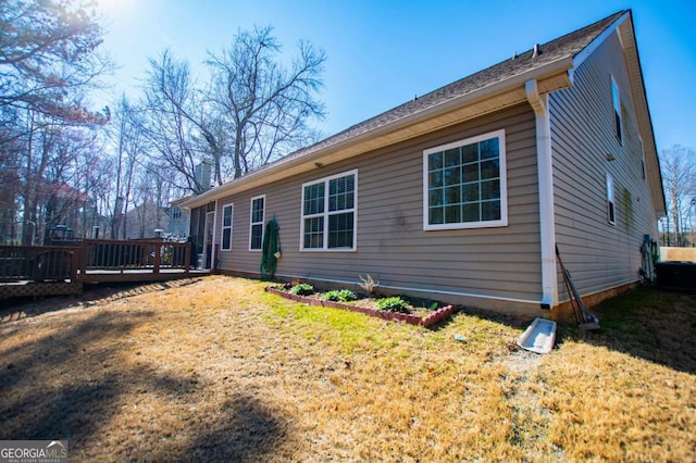 exterior space featuring central AC, a yard, and a wooden deck